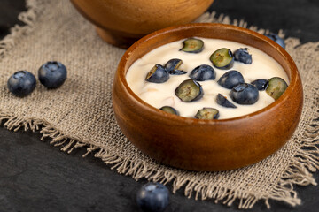 Fototapeta na wymiar ripe blueberries and fresh creamy yogurt