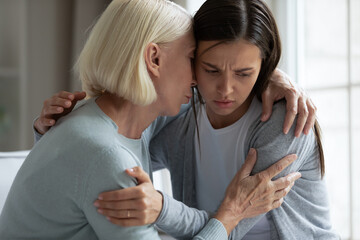 Caring mature mother comforting, hugging upset adult daughter close up, loving older grandmother...