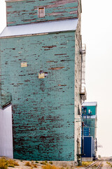 Three grain elevators and rail cars. Warner, Alberta, Canada