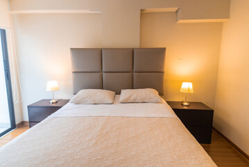 cama con cabecera y muebles en departamento