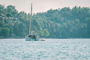Catamaran sailboat anchored at Bang Thao beach shore in Thailand
