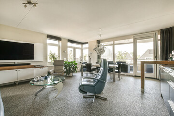 a living room with couches, chairs and a flat screen tv on the wall in the corner of the room