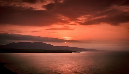 Fototapeta premium Photography of red sunset at sea with mountains in the background and black vignette on the sides