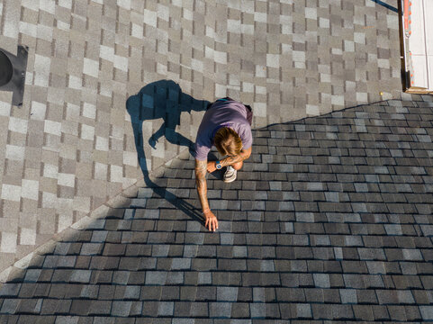 Sunny High Resolution Top Down Aerial Drone View of a Roofing Project Manager Performing A Residential Roof Inspection: Roofing, Architecture, Real Estate, Insurance, Occupations