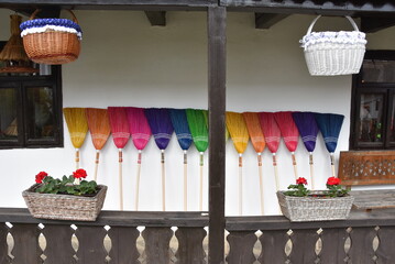 View of colored brooms on a white wall on a balcony