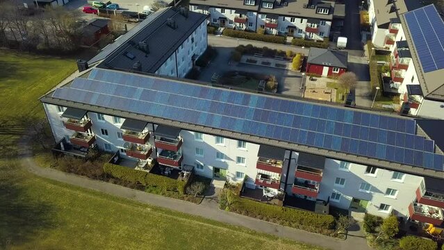 Solar photovoltaic panels mounted on roof of Swedish condo building in Linkoping residential area. Renewable electricity development