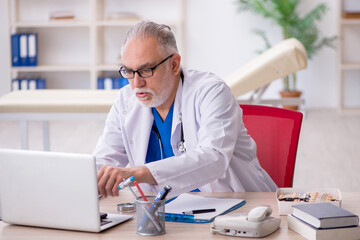 Old male doctor in telemedicine concept