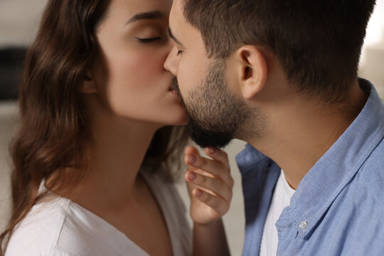 Love relationship. Passionate young couple kissing indoors, closeup