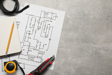 Wiring diagrams, wires and tools on grey table, flat lay. Space for text
