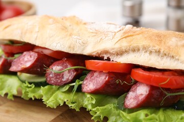 Delicious sandwich with sausages and vegetables on table, closeup