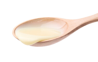 Wooden spoon with condensed milk isolated on white