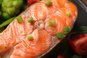 Healthy meal. Grilled salmon steak, green onion and vegetables on table, closeup