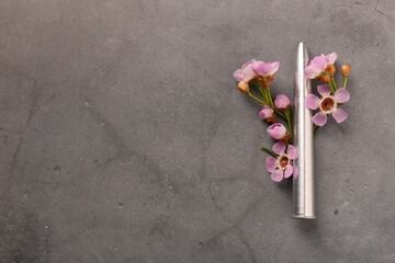 Bullet and beautiful flowers on grey textured table, flat lay. Space for text