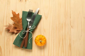 Fotobehang Napkin, cutlery and pumpkin on light wooden background, flat lay with space for text. Stylish autumn table setting © New Africa