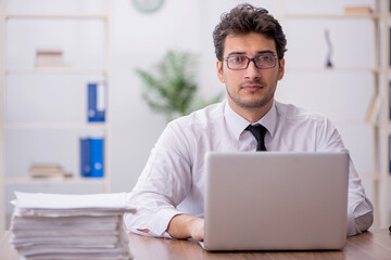 Young male employee and too much work in the office