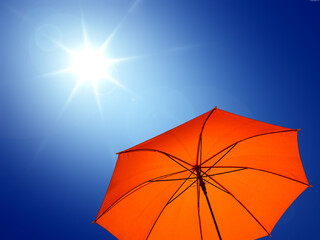 umbrella in the sun against blue sky. Hot summer relaxation and vacation concept