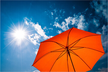 umbrella in the sun against blue sky. Hot summer relaxation and vacation concept