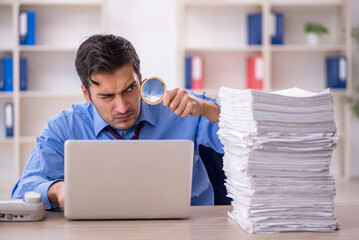 Young male employee and too much work in the office