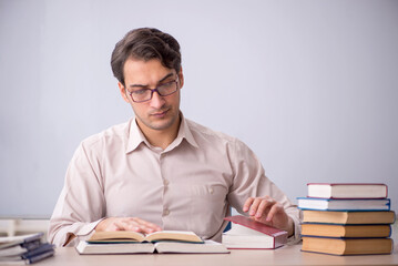 Young male teacher student sitting in the classroom