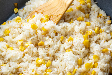 コーンチャーハンをフライパンで作る調理シーン。
