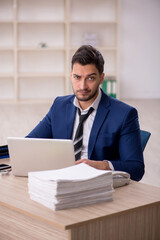 Fototapeta premium Young male employee working in the office
