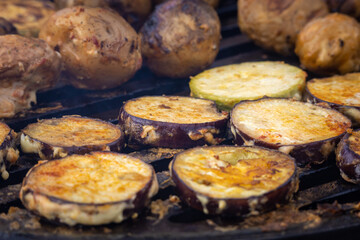 Vegetables are grilled on the grill. Potatoes, zucchini and eggplants are grilled in the smoke in the open air. Vegetarian food. Vegan BBQ. Street food