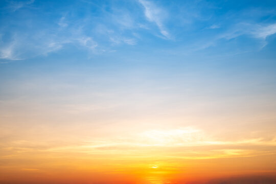 Real amazing Beautiful sunrise and luxury soft gradient orange gold clouds with sunlight on the blue sky perfect for the background, take in everning, Twilight sunset sky with gentle colorful clouds