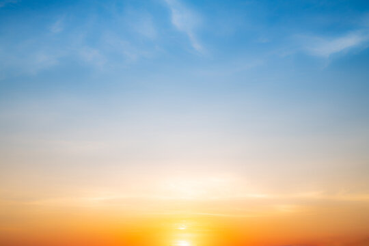 Real amazing Beautiful sunrise and luxury soft gradient orange gold clouds with sunlight on the blue sky perfect for the background, take in everning, Twilight sunset sky with gentle colorful clouds