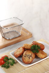 fried potato cheese balls croquettes with tomato ketchup served in a basket. white background and garnish