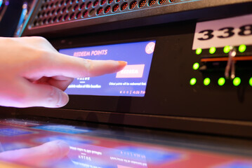 Motion of people pressing redeem button on slot machine inside Casino