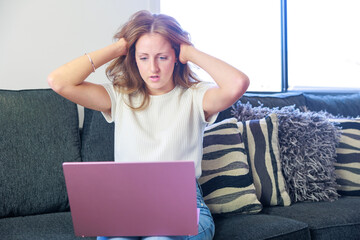 パソコンを見ながら頭を抱える女性