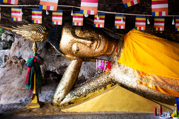 Ancient buddha reclining statue in antique stone cave of Wat Khao Phra Si Sanphet Chayaram temple...