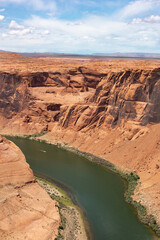 Scenic Vertical Shot of Horseshoe Bend canyon overlooking Colorado River in Page Arizona, USA. Bright Blue Sky.