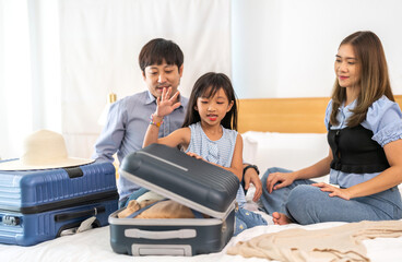 Portrait of love asian family father and mother with girl traveler packing stuff and outfit clothes in suitcases travel bag luggage for summer holiday weekend tourist vacation trip at home.travel