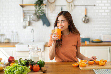 Portrait of beauty healthy asian woman making orange fruit smoothie with blender.girl preparing cooking detox cleanse with fresh orange juice in kitchen at home.health, vitamin c, diet, healthy drink