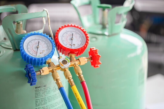 Manifold tool gauge bucket refrigerant applies to car air conditioning with blurred technician repairman check car air conditioning system refrigerant recharge, Car Air Conditioning Repair