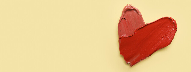 Heart made of lipstick on beige background with space for text, top view