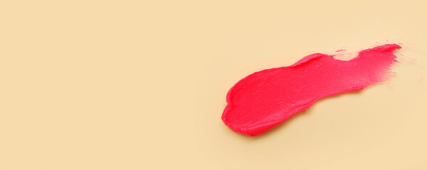 Pink lipstick stroke on beige background with space for text, top view