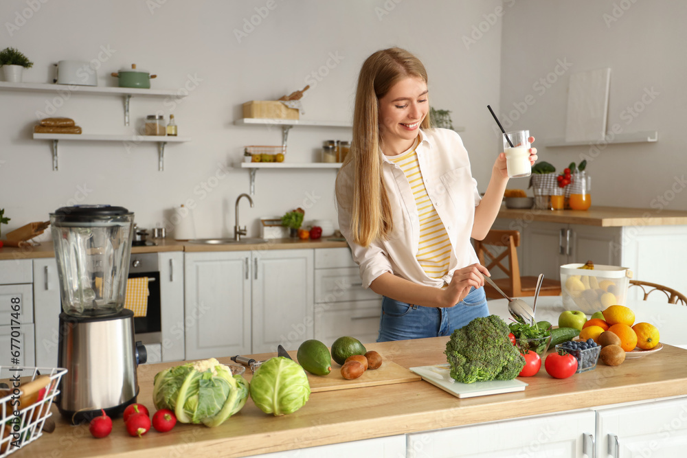 Canvas Prints Young woman with vegetables and glass of milk in kitchen