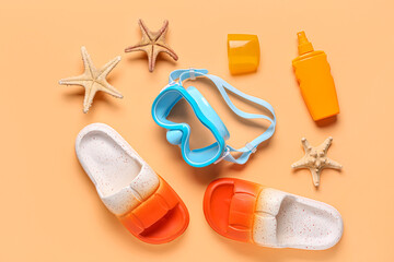 Composition with snorkeling mask, flip-flops and bottle of sunscreen cream on color background