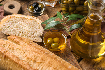 Obraz na płótnie Canvas Jug and bowl of fresh olive oil with bread on wooden background