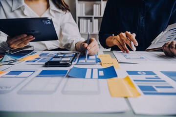 Close up ux developer and ui designer brainstorming about mobile app interface wireframe design on...