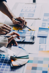 Close up ux developer and ui designer brainstorming about mobile app interface wireframe design on...