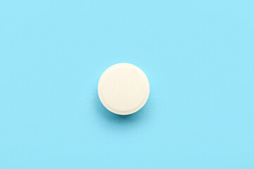 Fototapeta na wymiar White medical pill on blue background