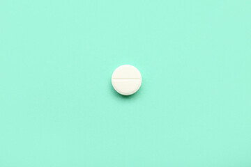White medical pill on turquoise background