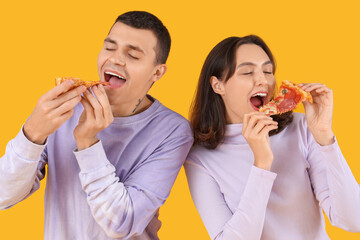 Young couple eating tasty pepperoni pizza on color background