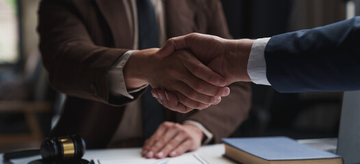 Lawyers shake hands with business people to seal a deal with partner lawyers or a lawyer discussing contract agreements, handshake concepts, agreements. - obrazy, fototapety, plakaty