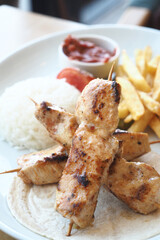 Chicken skewers with french fries and rice 