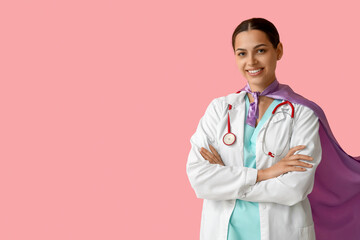 Beautiful female doctor in superhero costume on pink background - obrazy, fototapety, plakaty