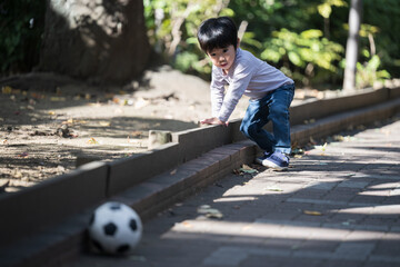 公園でサッカーボールを追いかける男の子　事故が危ない！